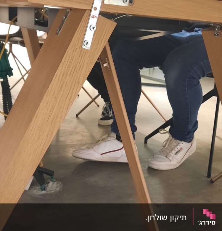 חיבורי מתכת על שולחן עץ עם רגליים משולשות